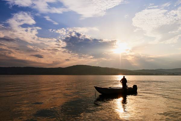 Ein Fischer auf dem Boot im romantischen Morgenlicht von Robert Kalb