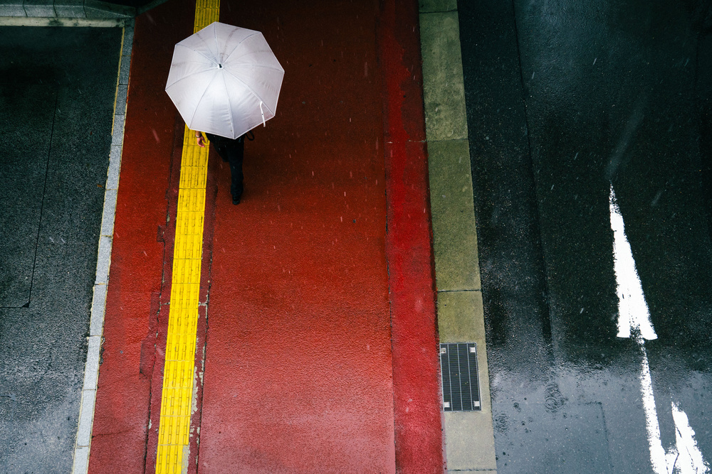 Der rote Bürgersteig und ein weißer Regenschirm von Tetsuya Hashimoto